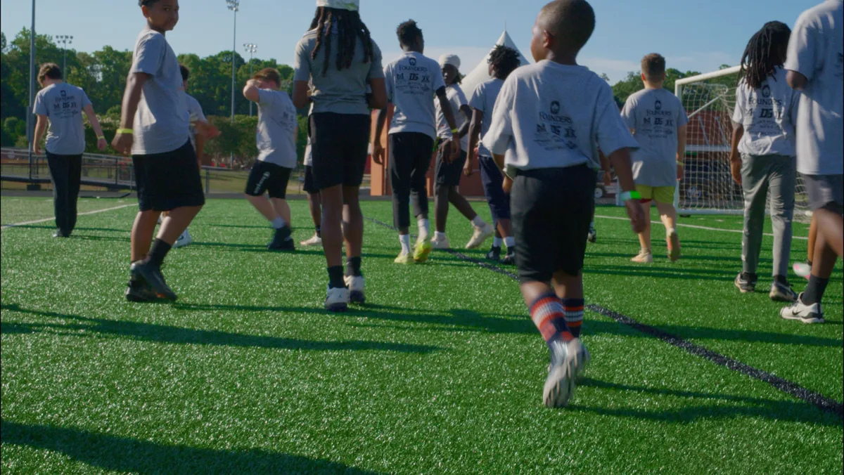 Young athletes training together on the field at a F.A.S.T. Foundation camp